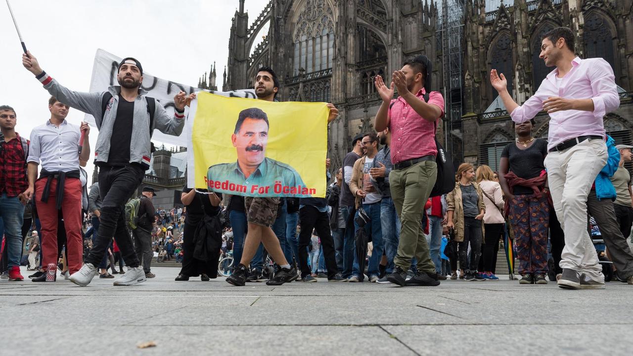 Kurden tanzen am 31.07.2016 am Hauptbahnhof in Köln (Nordrhein-Westfalen) mit einer Öcalan Fahne. Kurden tanzen am 31.07.2016 am Hauptbahnhof in Köln (Nordrhein-Westfalen) mit einer Öcalan Fahne.