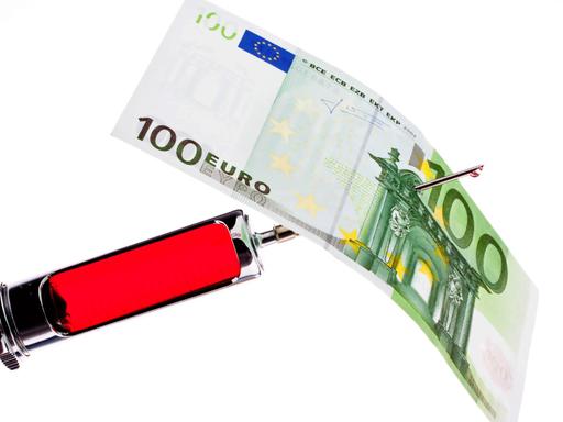 Injektionsspritze und -nadel mit aufgespiesstem 100-Euro-Schein