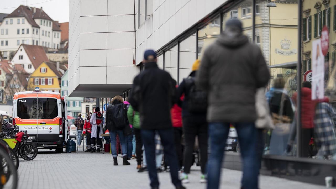 Einige Menschen stehen in einer Schlange um sich für einen Schnelltest in der Tübinger Innenstadt anzumelden. Einige Menschen stehen in einer Schlange um sich für einen Schnelltest in der Tübinger Innenstadt anzumelden.