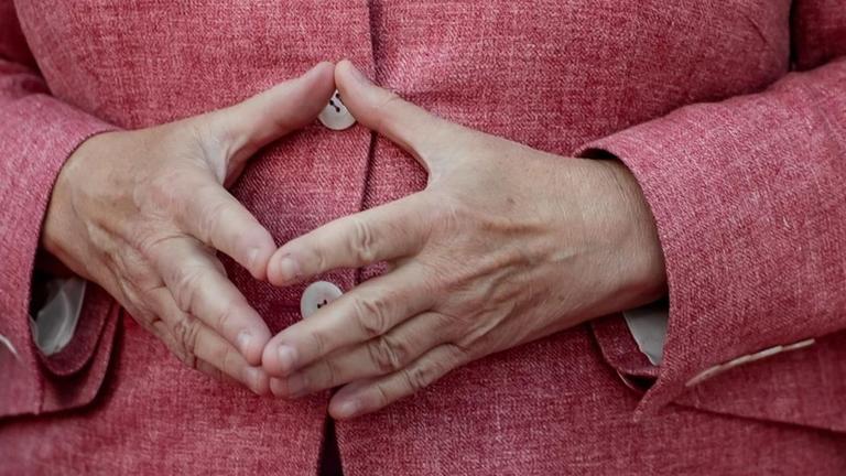 Bundeskanzlerin Angela Merkel hat die Hände zur Raute aneinandergelegt Bundeskanzlerin Angela Merkel hat die Hände zur Raute aneinandergelegt