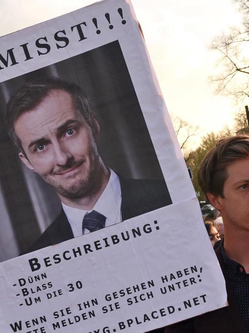 Der Schauspieler Max Mauff hält am 08.04.2016 in Marl (Nordrhein-Westfalen) vor der Verleihung der Grimmepreise eine Plakat mit der Aufschrift "Vermisst", das auf die Abwesenheit des Satirikers Jan Böhmermann hin weist.