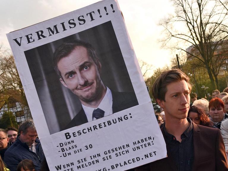 Der Schauspieler Max Mauff hält am 08.04.2016 in Marl (Nordrhein-Westfalen) vor der Verleihung der Grimmepreise eine Plakat mit der Aufschrift "Vermisst", das auf die Abwesenheit des Satirikers Jan Böhmermann hin weist.