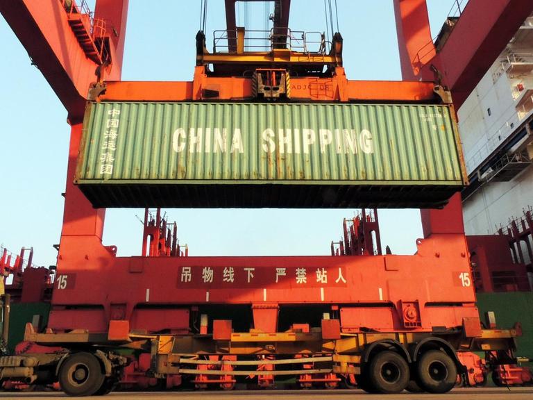 In einem Hafen im Osten Chinas werden Container verladen.