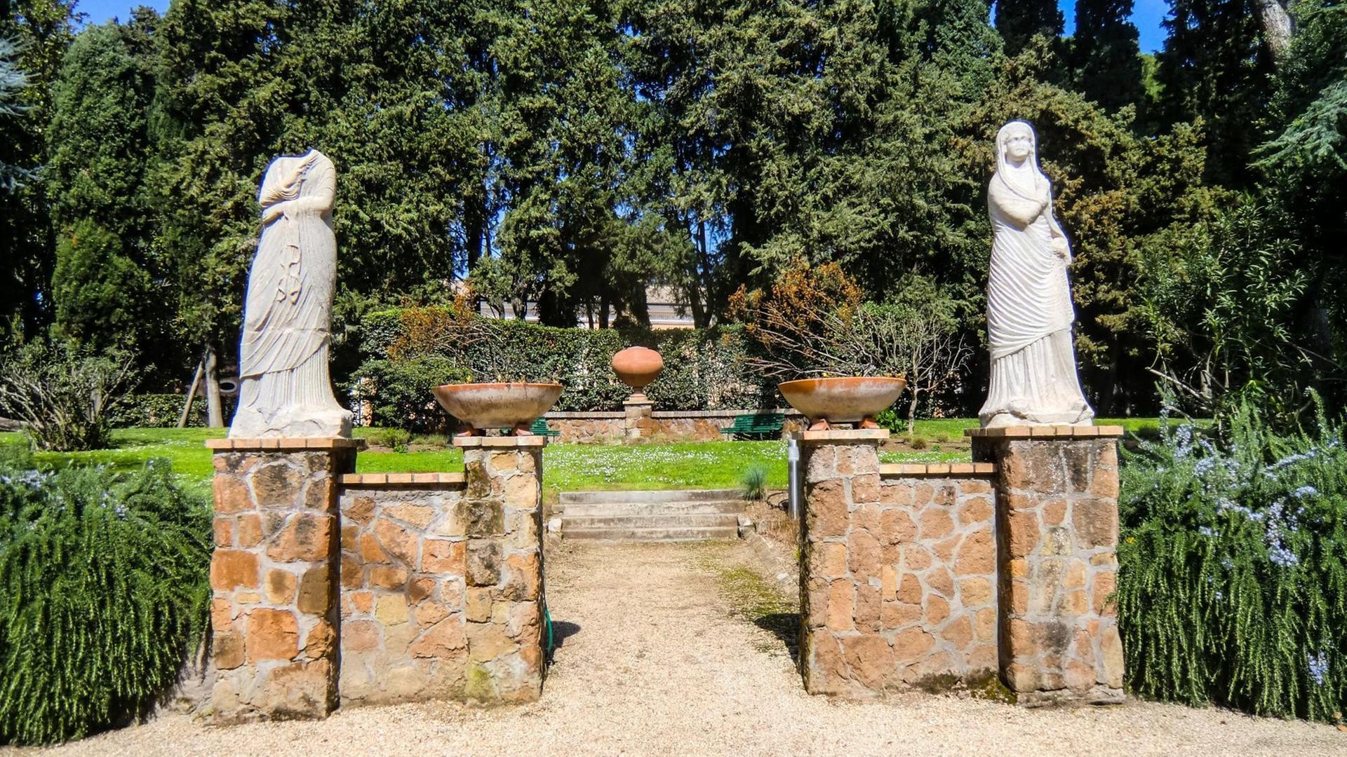 Blick in einen Teil des Gartens der Villa Massimo, der mit zwei nur teilweise erhaltenen, weißen Frauen-Marmorfiguren geschmückt ist. Blick in einen Teil des Gartens der Villa Massimo, der mit zwei nur teilweise erhaltenen, weißen Frauen-Marmorfiguren geschmückt ist.