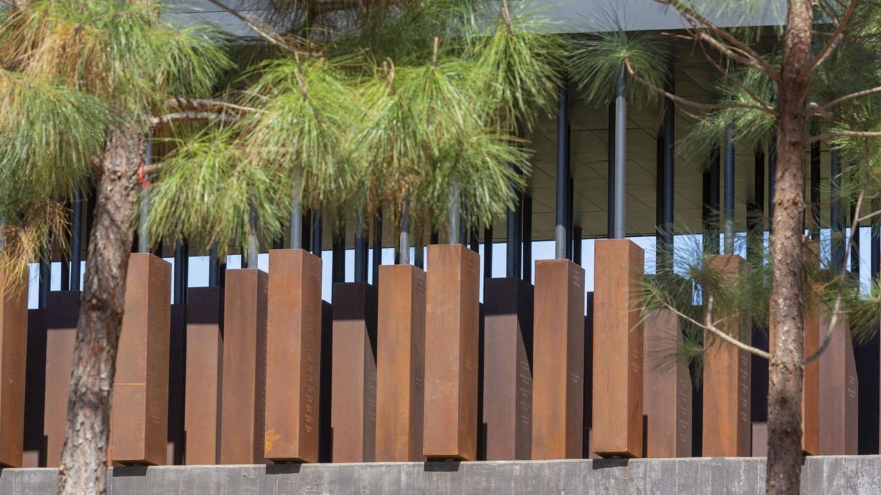 Blick auf das "National Memorial for Peace and Justice" in Montgomery, Alabama, mit Stahlkörpern und Bäumen davor Blick auf das "National Memorial for Peace and Justice" in Montgomery, Alabama, mit Stahlkörpern und Bäumen davor