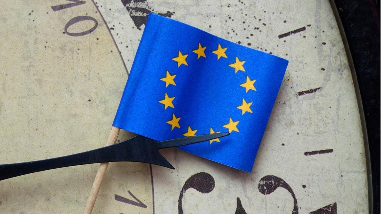Uhrdetail mit Zeiger zwischen 2 und 3 und Fähnchen der EU Uhrdetail mit Zeiger zwischen 2 und 3 und Fähnchen der EU