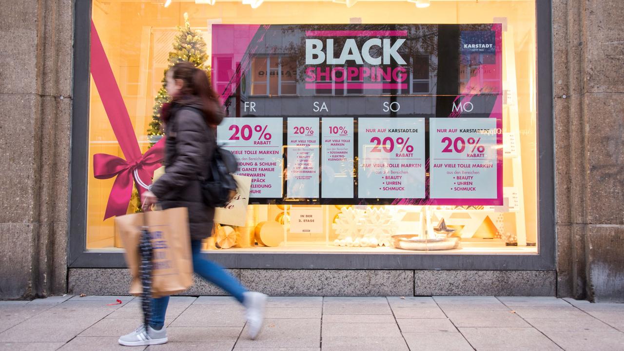 Eine shoppende Frau geht am 24.11.2017, dem Black Friday, in Hamburg am Schaufenster eines Geschäfts entlang.