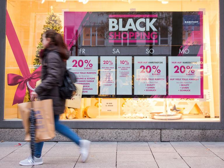 Eine shoppende Frau geht am 24.11.2017, dem Black Friday, in Hamburg am Schaufenster eines Geschäfts entlang.