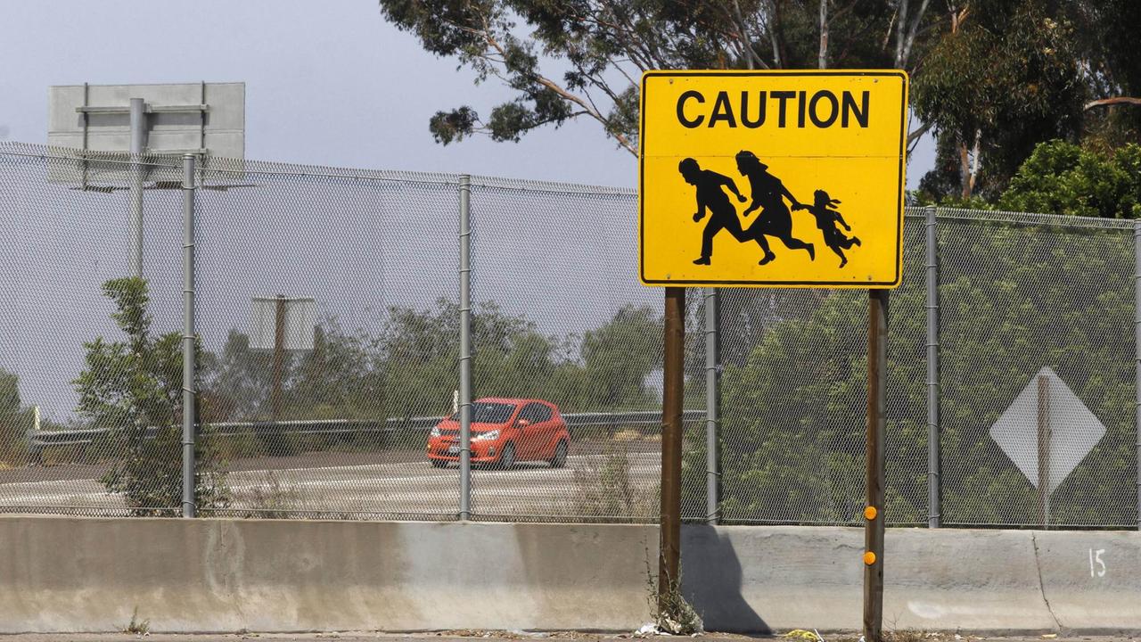 Ein Straßenschild in Ysidro warnt vor Flüchtlingen, die die Fahrbahn überqueren. Ein Straßenschild in Ysidro warnt vor Flüchtlingen, die die Fahrbahn überqueren.