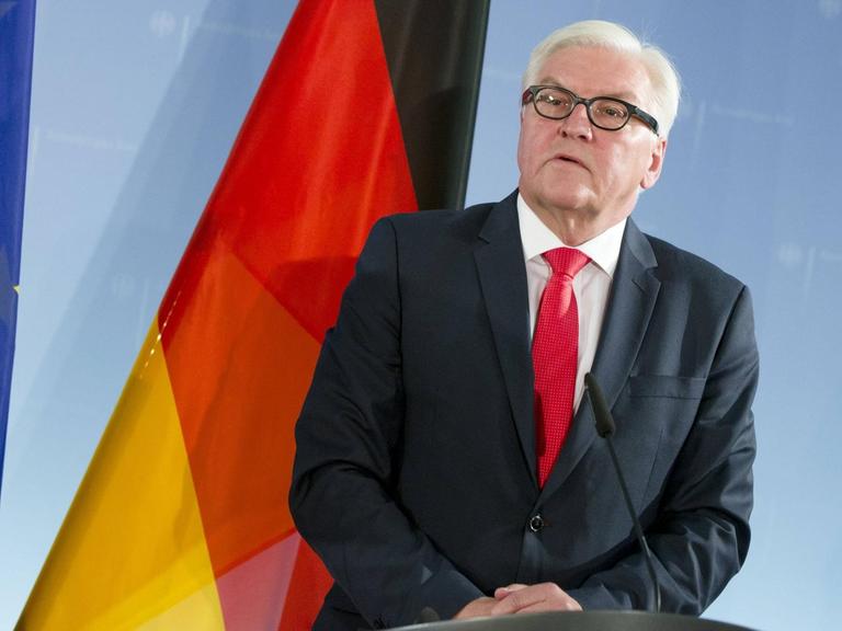 Bundesaußenminister Frank-Walter Steinmeier vor einer deutschen und europäischen Flagge stehend