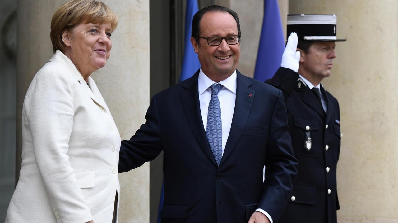 Einen Tag vor dem EU-Gipfeltreffen begrüßt der französische Präsident Hollande Bundeskanzlerin Merkel im Elysee-Palast in Paris