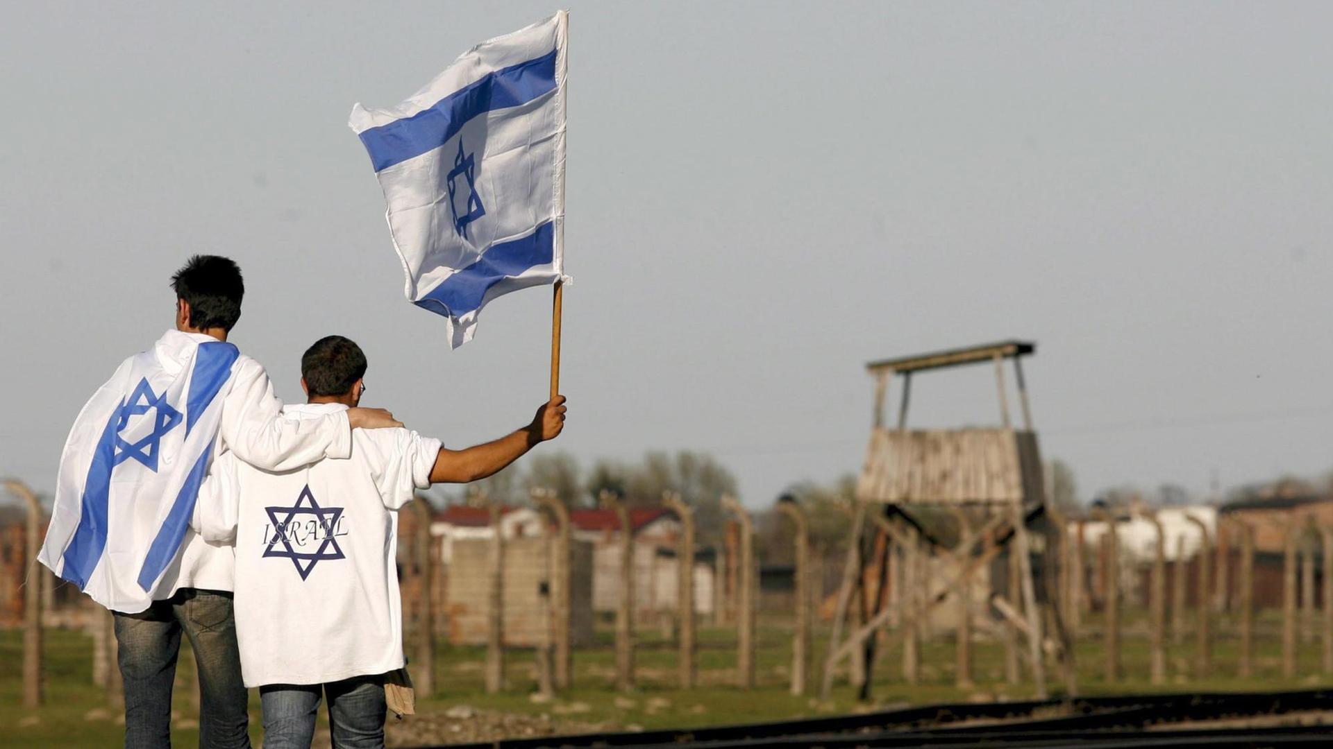 Junge Israelis stehen mit der israelischen Flaggen am Konzentrationslager Birkenau in Polen