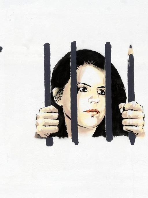 Foto eines Banksy Graffitis, das Zehra Doğan hinter Gittern zeigt.