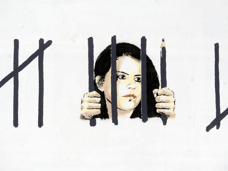 Foto eines Banksy Graffitis, das Zehra Doğan hinter Gittern zeigt.