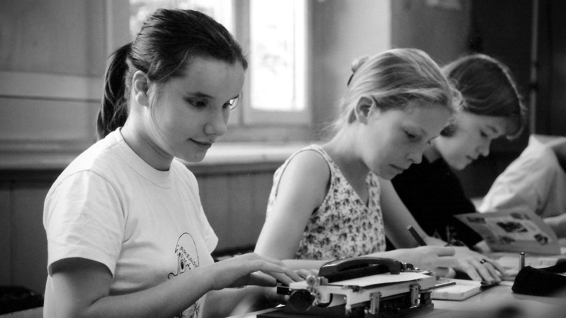 Eine blinde Integrationsschülerin, die in den 1990er Jahren mit einer lauten Schreibmaschine die Braille-Schrift auf das Papier stanzen musste. Eine blinde Integrationsschülerin, die in den 1990er Jahren mit einer lauten Schreibmaschine die Braille-Schrift auf das Papier stanzen musste.