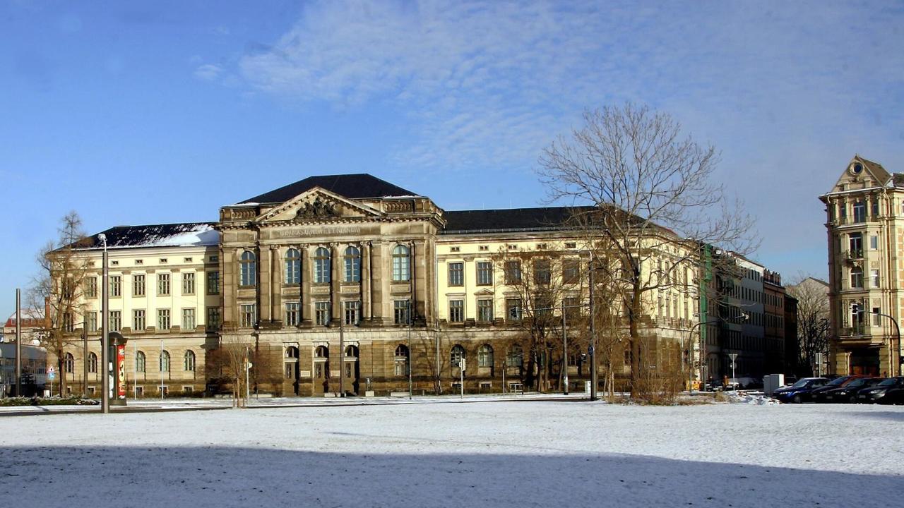 Ein historischer Großbau an einem weitläufigen Platz, der mit Schnee bedeckt ist. Ein historischer Großbau an einem weitläufigen Platz, der mit Schnee bedeckt ist.