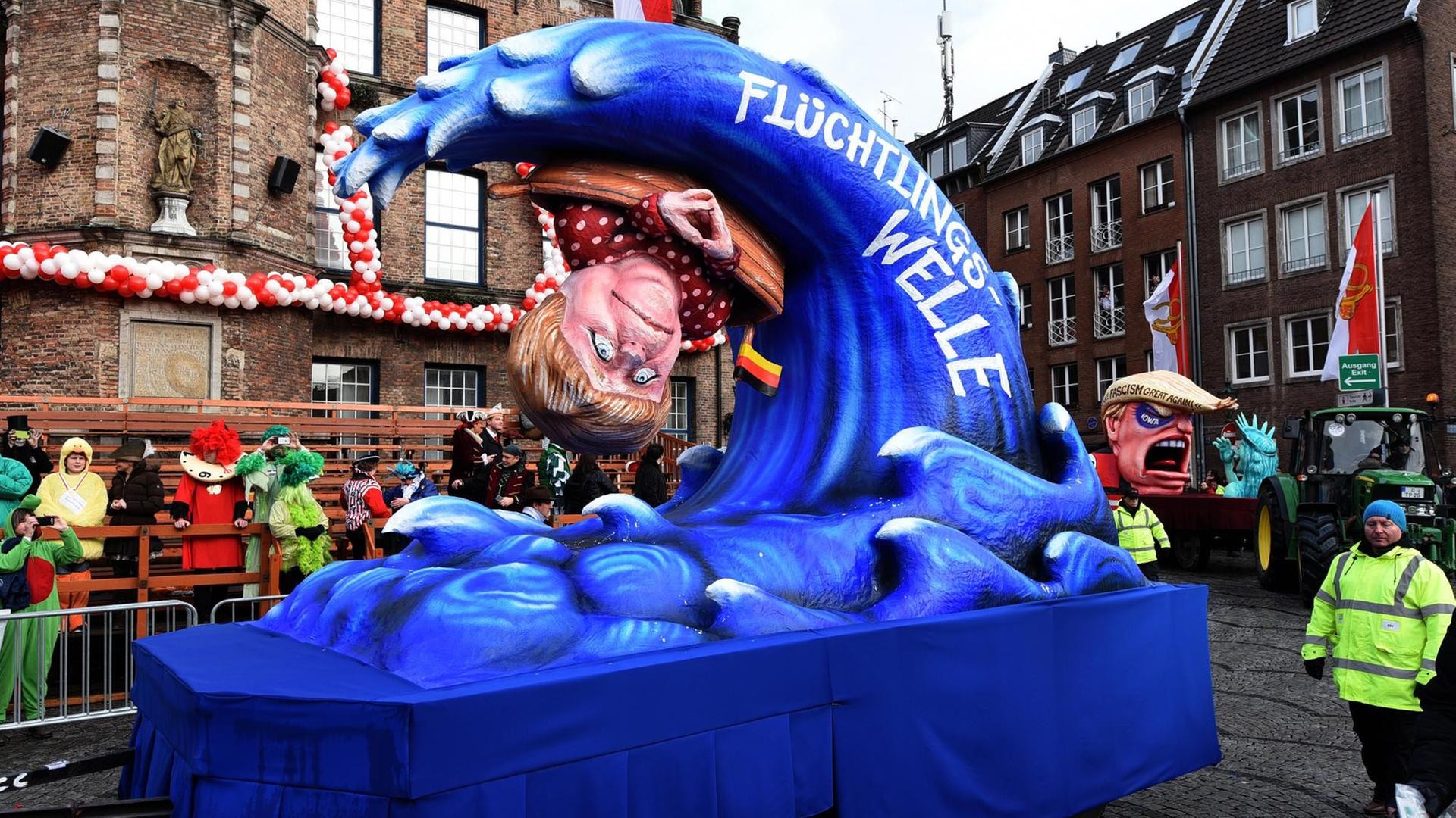 Von der Flüchtlingswelle erfasst: Angela Merkel wurde beim Düsseldorfer Umzug mit zahlreichen Motivwagen bedacht. Von der Flüchtlingswelle erfasst: Angela Merkel wurde beim Düsseldorfer Umzug mit zahlreichen Motivwagen bedacht.