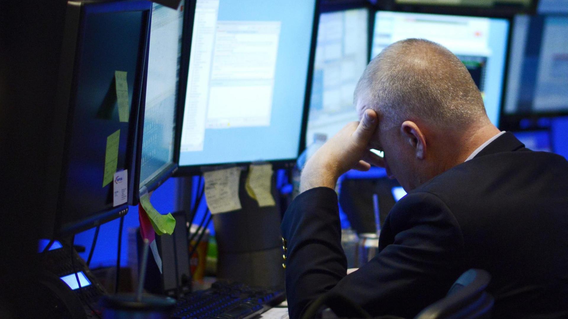 Ein Börsenmakler an der Wall Street in New York legt das Gesicht angesichts hoher Kursverluste in die Hände.