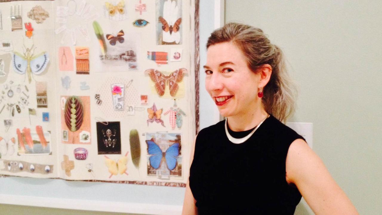 Die Selfie-Forscherin Elizabeth Otto posiert neben einem Bild und lächelt verschmitzt in die Kamera