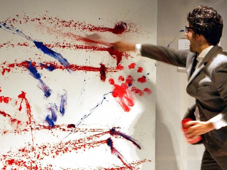 Mit großzügigen Strichen gestaltet Christoph Schlingensief bei der Fotoprobe zu seiner Aktion "Atta Atta - Die Kunst ist ausgebrochen" am 22.1.2003 an der Berliner Volksbühne ein Wandbild.