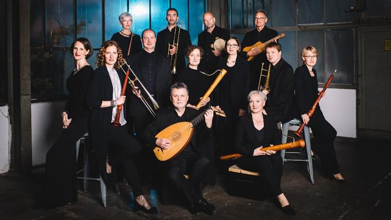 Die Mitglieder stehen beieinander mit ihren Instrumenten. Die Mitglieder stehen beieinander mit ihren Instrumenten.