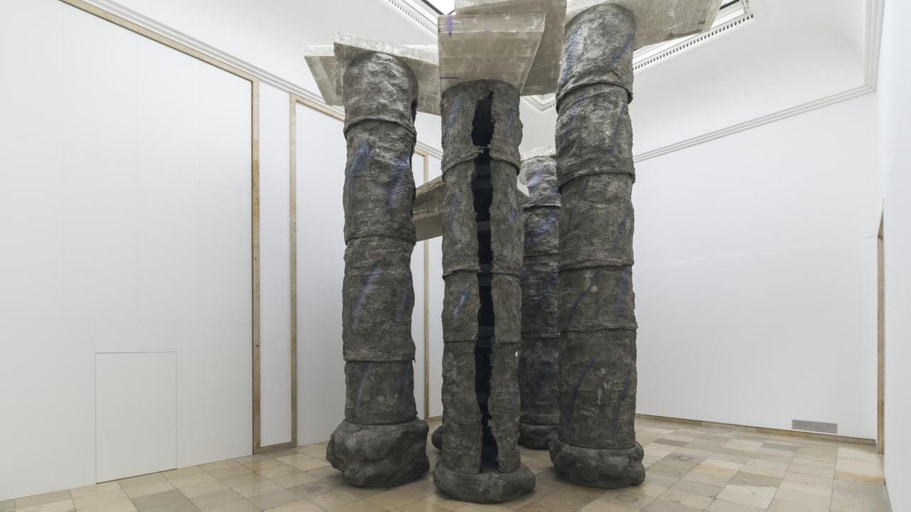 Installationsansicht der Skulptur-Ausstellung von Phyllida Barlow im Haus der Kunst in München. Hier stehen hohle Metallsäulen, auf denen oben Betonplatten balacieren. Installationsansicht der Skulptur-Ausstellung von Phyllida Barlow im Haus der Kunst in München. Hier stehen hohle Metallsäulen, auf denen oben Betonplatten balacieren.
