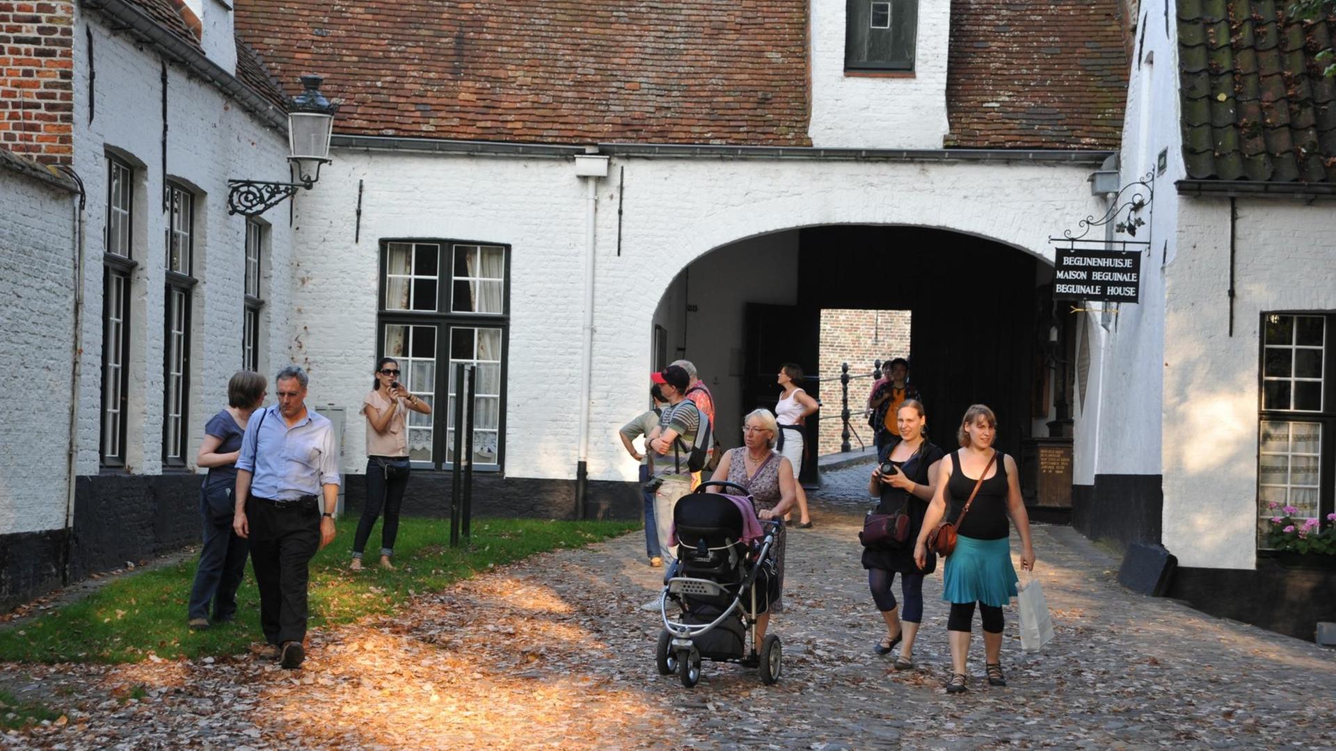 Touristengruppe im Beginenhof (flämisch: Begijnenhof) im belgischen Brügge Touristengruppe im Beginenhof (flämisch: Begijnenhof) im belgischen Brügge
