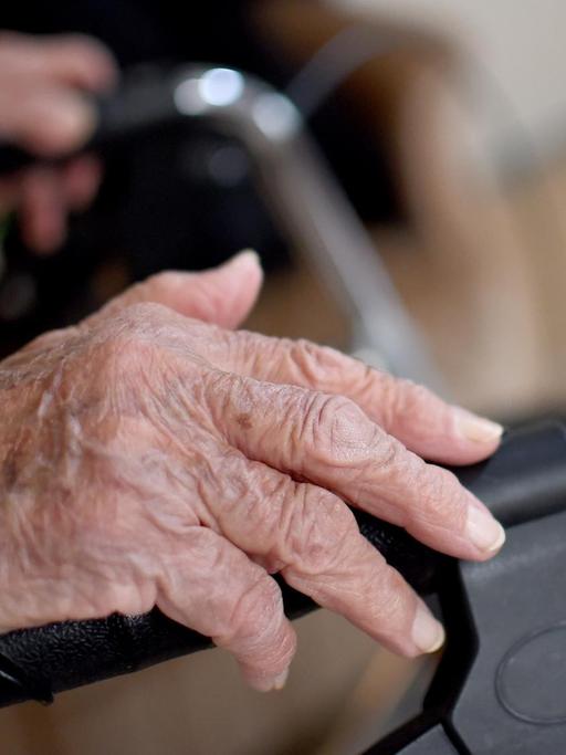 Eine alte Frau schiebt in Berlin einen Rollator.