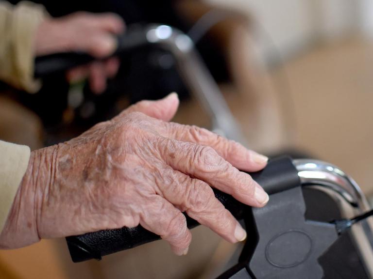 Eine alte Frau schiebt in Berlin einen Rollator.