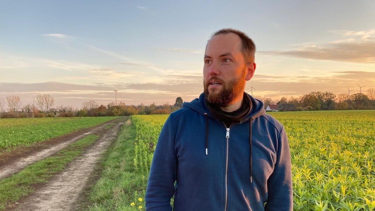 Philipp Gerhardt steht vor einem Acker. Philipp Gerhardt steht vor einem Acker.