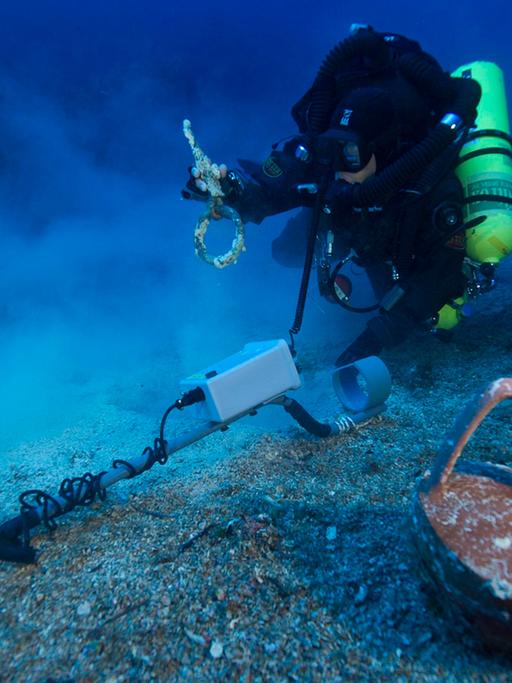 Ein Taucher vor einem fast unversehrten Krug in der Nähe der Insel Antikythera in Griechenland während einer Erkundung der Stelle, an dem das berühmte Schiff Antikythera gesunken war.