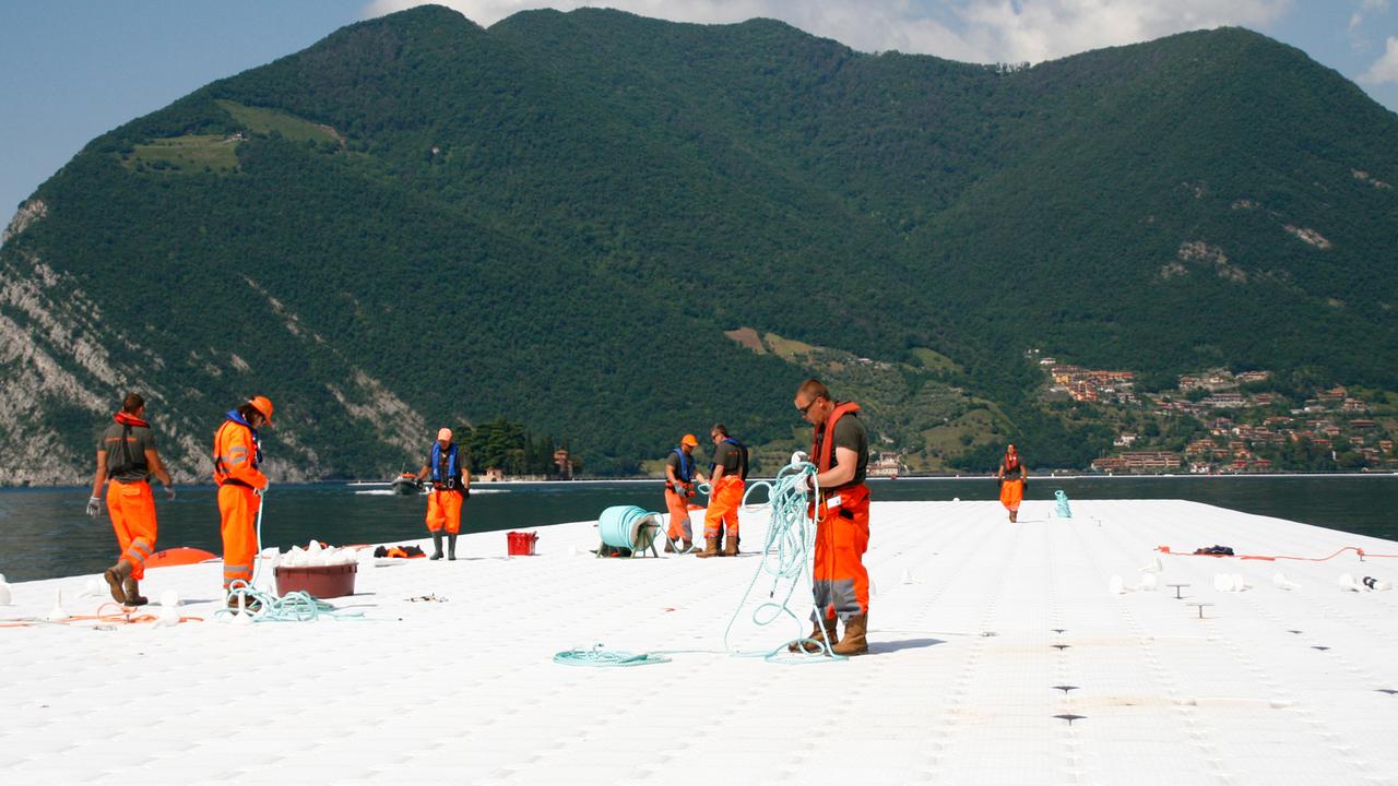 Christos "Floating Piers": Die schwimmenden Stege wachsen langsam in den See. Christos "Floating Piers": Die schwimmenden Stege wachsen langsam in den See.