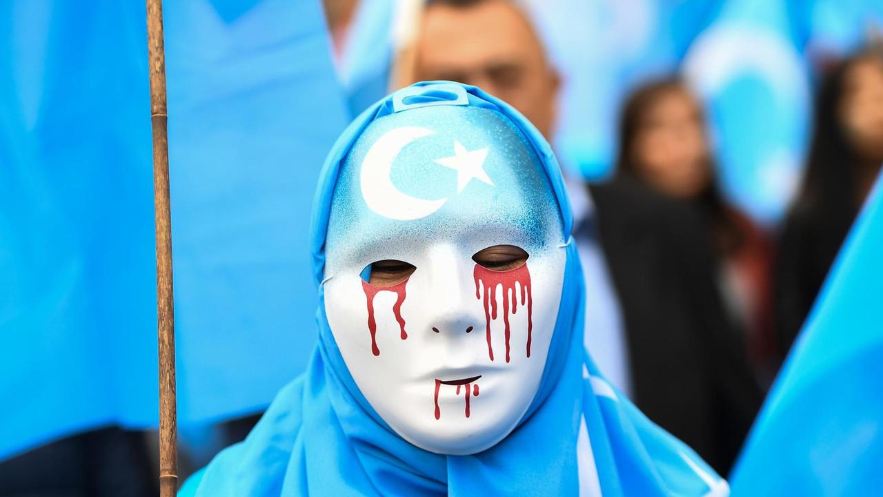 27. April 2018 in Brüssel: Maskierte Person auf einem Protestmarsch für die Schließung der chinesischen Umerziehungslager, in denen Uiguren aus der Autonomen Region Xinjiang festgehalten werden 27. April 2018 in Brüssel: Maskierte Person auf einem Protestmarsch für die Schließung der chinesischen Umerziehungslager, in denen Uiguren aus der Autonomen Region Xinjiang festgehalten werden