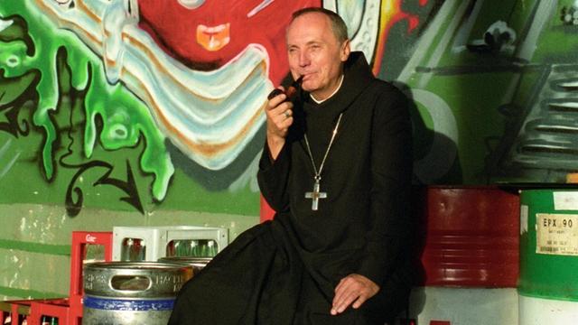 Porträt des Benediktinermönchs Notker Wolf beim Pfeife Rauchen.