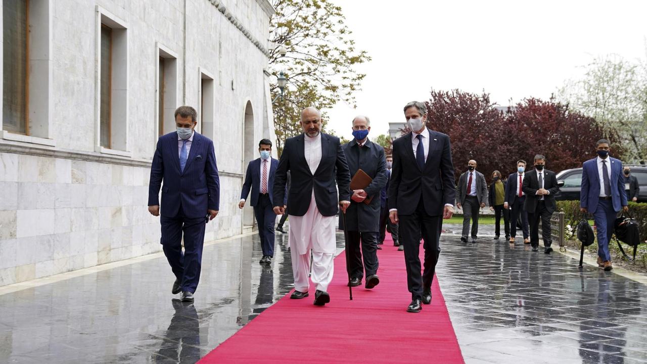 US-Außenminister Blinken geht mit dem afghanischen Präsidenten Ghani über einen roten Teppich.