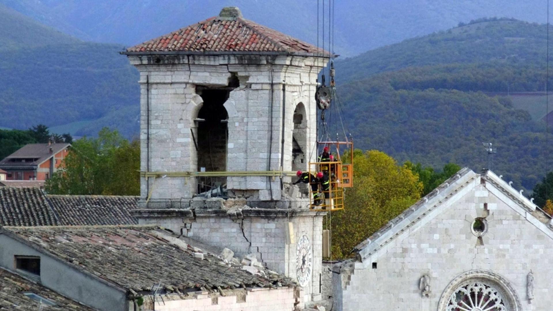Feuerwehrleute stabilisieren den Rathausturm von Norcia Feuerwehrleute stabilisieren den Rathausturm von Norcia
