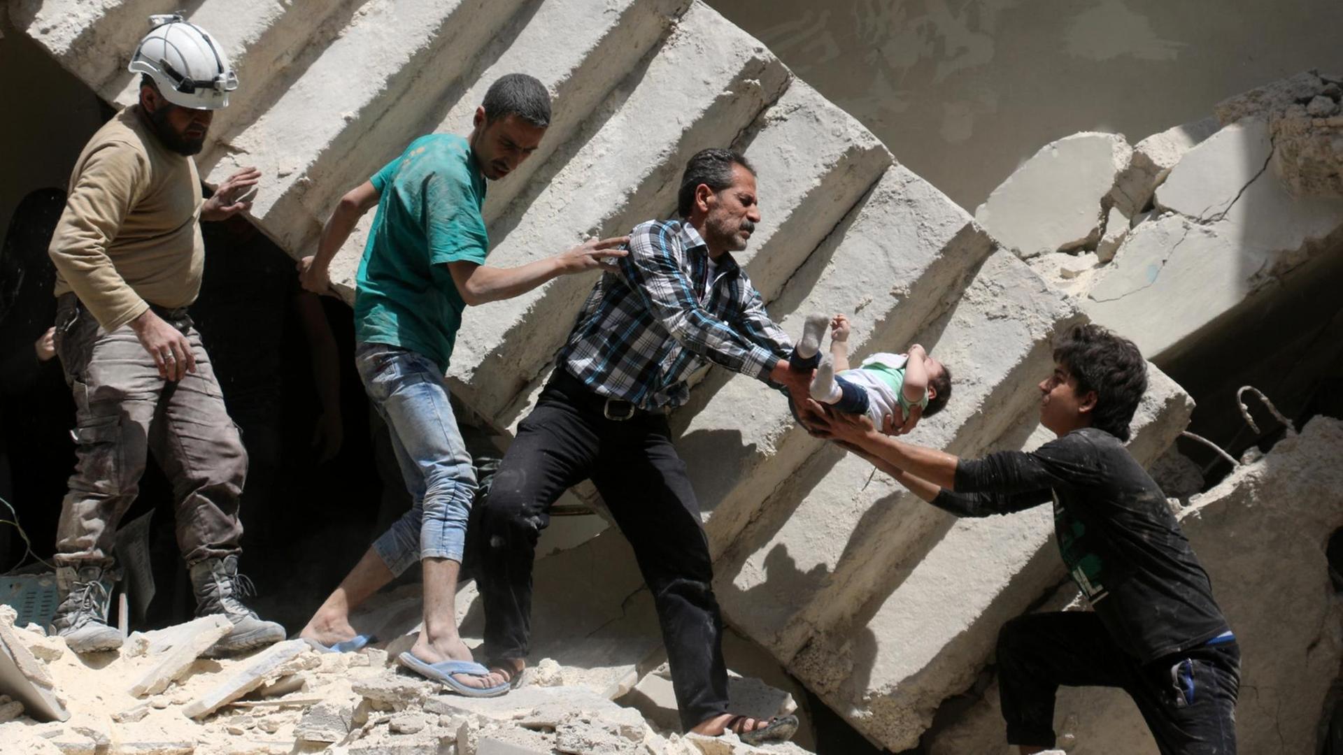 Helfer tragen ein Kind aus den Trümmern nach Luftangriffen auf Aleppo. Helfer tragen ein Kind aus den Trümmern nach Luftangriffen auf Aleppo.