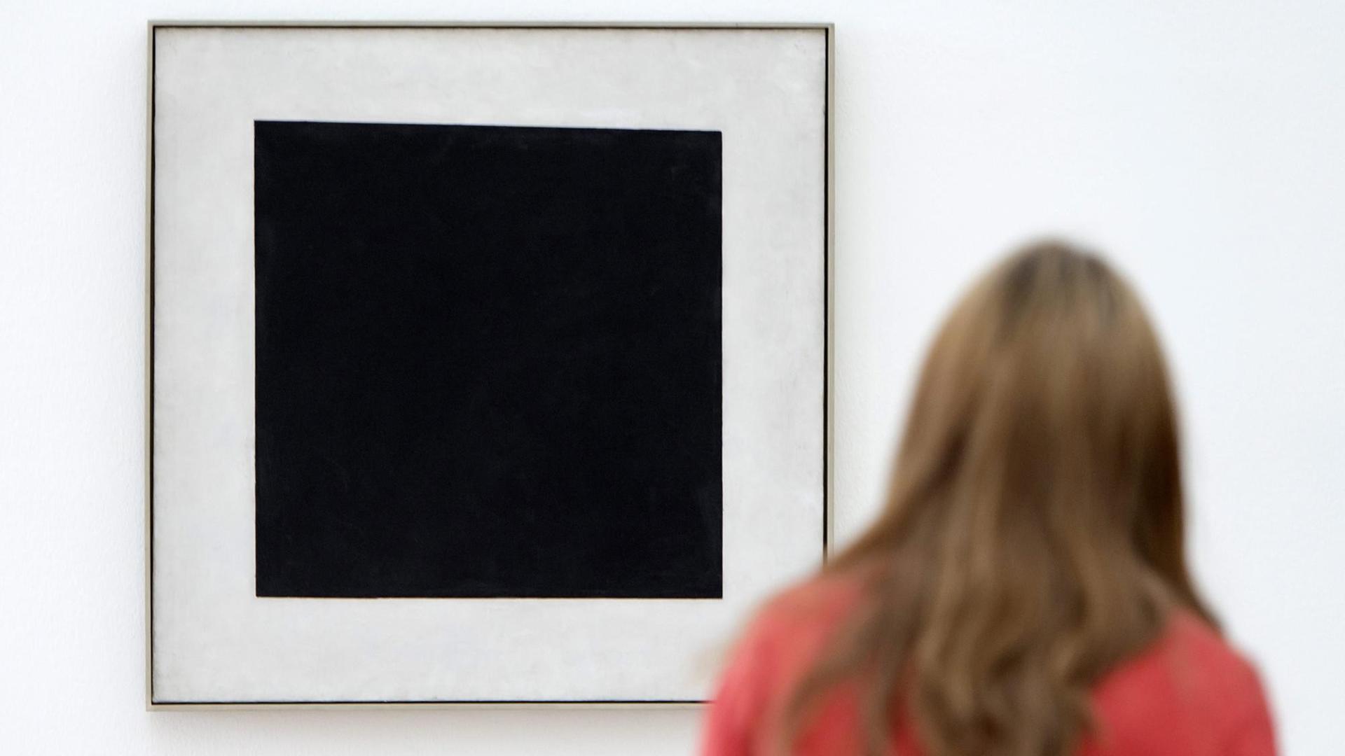 Eine Besucherin betrachtet in der Ausstellung "Auf der Suche nach 0,10" das Werk "Schwarzes Quadrat" von dem russischen Künstler Kasimir Malewitsch.