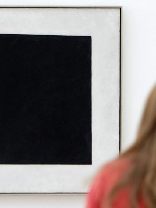 Eine Besucherin betrachtet in der Ausstellung "Auf der Suche nach 0,10" das Werk "Schwarzes Quadrat" von dem russischen Künstler Kasimir Malewitsch.