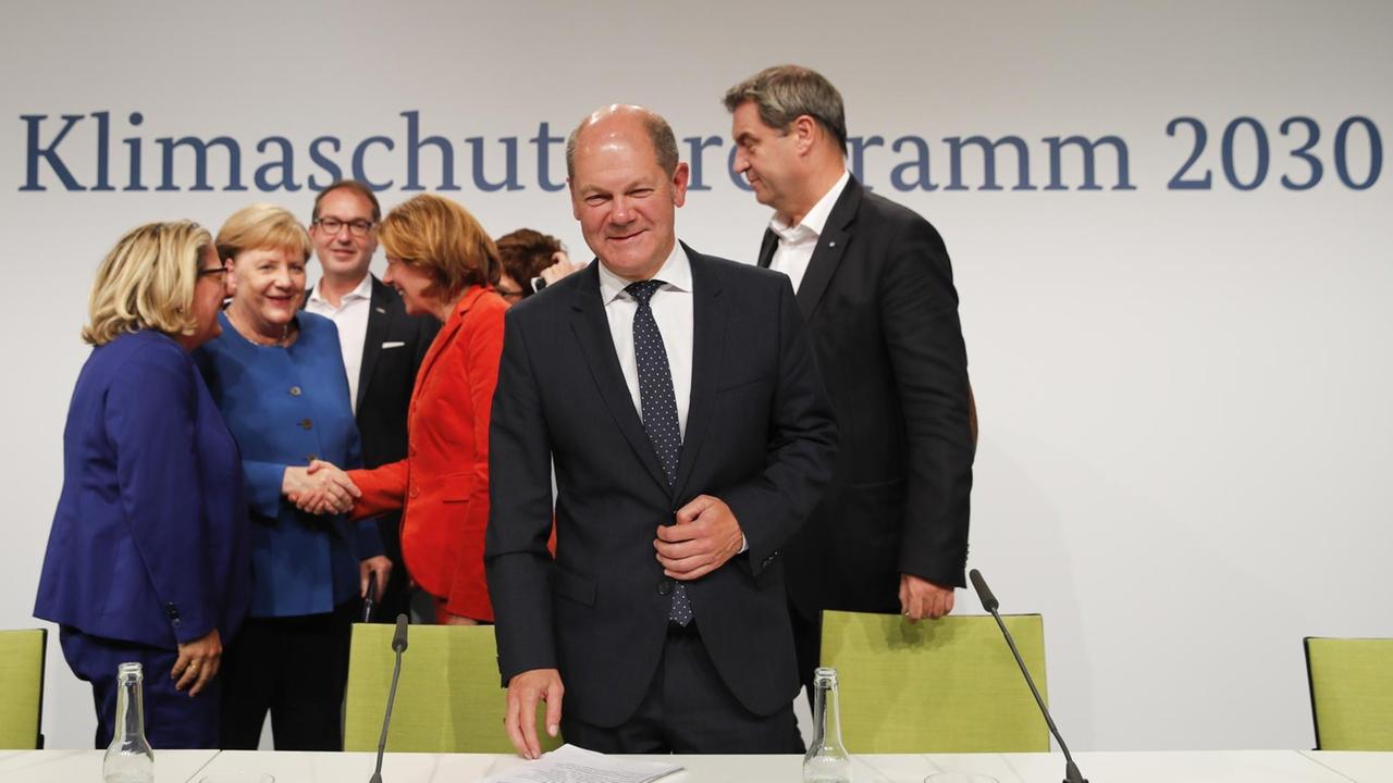 Bundesumweltministerin Svenja Schulze, Bundeskanzlerin Angela Merkel, stellvertretende Fraktionsvorsitzende der konservativen CSU-Fraktion Alexander Dobrindt. Die rheinland-pfälzische Ministerpräsidentin und stellvertretende Vorsitzende der Sozialdemokratischen Partei (SPD) Malu Dreyer, die Vorsitzende der CDU Annegret Kramp-Karrenbauer, der deutsche Finanzminister und Vizekanzler Olaf Scholz und der bayerische Ministerpräsident und Vorsitzende der CSU Markus Soeder beglüchwünschen sich nach bei der Pressekonferenz nach der Sitzung des Klimaausschusses am 20. September 2019 im Futurium in Berlin. Die Regierung von Bundeskanzlerin Angela Merkel kündigte ein umfassendes klimapolitisches Paket im Wert von mindestens 100 Milliarden Euro (110 Milliarden Dollar) bis 2030 an. Bundesumweltministerin Svenja Schulze, Bundeskanzlerin Angela Merkel, stellvertretende Fraktionsvorsitzende der konservativen CSU-Fraktion Alexander Dobrindt. Die rheinland-pfälzische Ministerpräsidentin und stellvertretende Vorsitzende der Sozialdemokratischen Partei (SPD) Malu Dreyer, die Vorsitzende der CDU Annegret Kramp-Karrenbauer, der deutsche Finanzminister und Vizekanzler Olaf Scholz und der bayerische Ministerpräsident und Vorsitzende der CSU Markus Soeder beglüchwünschen sich nach bei der Pressekonferenz nach der Sitzung des Klimaausschusses am 20. September 2019 im Futurium in Berlin. Die Regierung von Bundeskanzlerin Angela Merkel kündigte ein umfassendes klimapolitisches Paket im Wert von mindestens 100 Milliarden Euro (110 Milliarden Dollar) bis 2030 an.