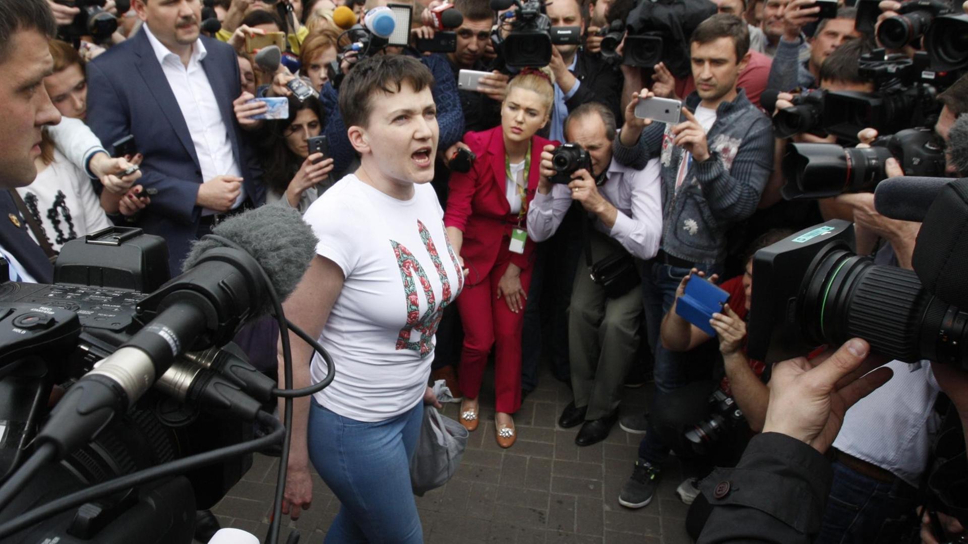 Die ukrainische Kampfpilotin Nadja Sawtschenko bei ihrer Ankunft in Kiew, umkreist von Kameras und Journalisten. Die ukrainische Kampfpilotin Nadja Sawtschenko bei ihrer Ankunft in Kiew, umkreist von Kameras und Journalisten.