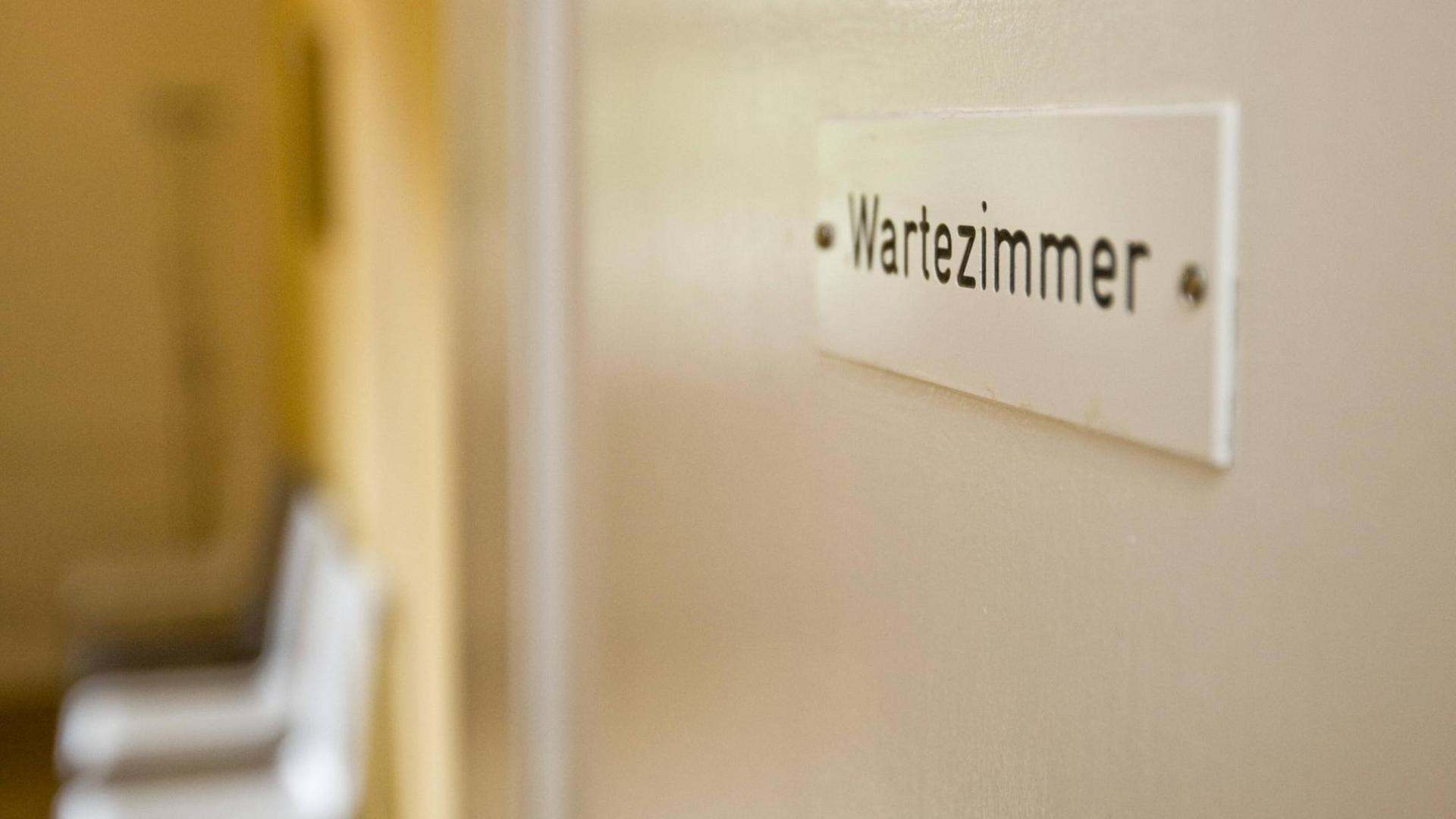 Schild mit der Aufschrift "Wartezimmer" an einer Tür. Schild mit der Aufschrift "Wartezimmer" an einer Tür.