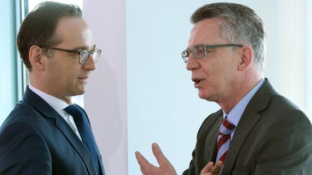 Bundesjustizminister Heiko Maas und Bundesinnenminister Thomas de Maiziere unterhalten sich auf einem Flur 