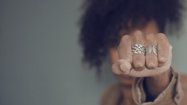 Eine Schwarze Frau reckt ihre Faust in die Kamera. Eine Schwarze Frau reckt ihre Faust in die Kamera.