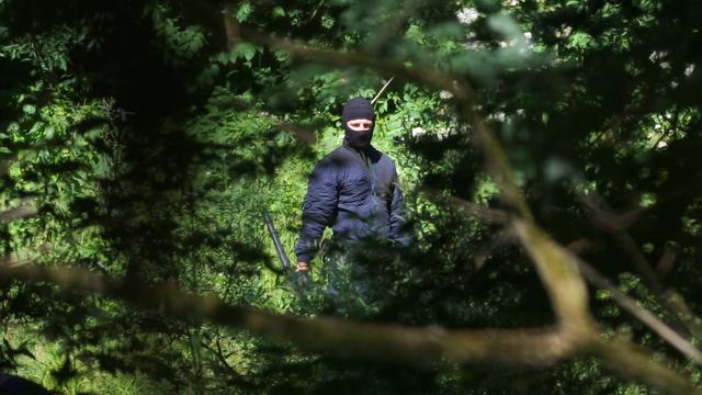 Ein maskierter Mann mit einem Tonfa-Knüppel Ein maskierter Mann mit einem Tonfa-Knüppel