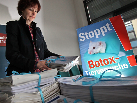 Corina Gericke vom Verein Ärzte gegen Tierversuche stapelt Listen mit rund 60.000 Unterschriften gegen Botox-Tierversuche auf einem Tisch der Behörde für Gesundheit und Verbraucherschutz in Hamburg.