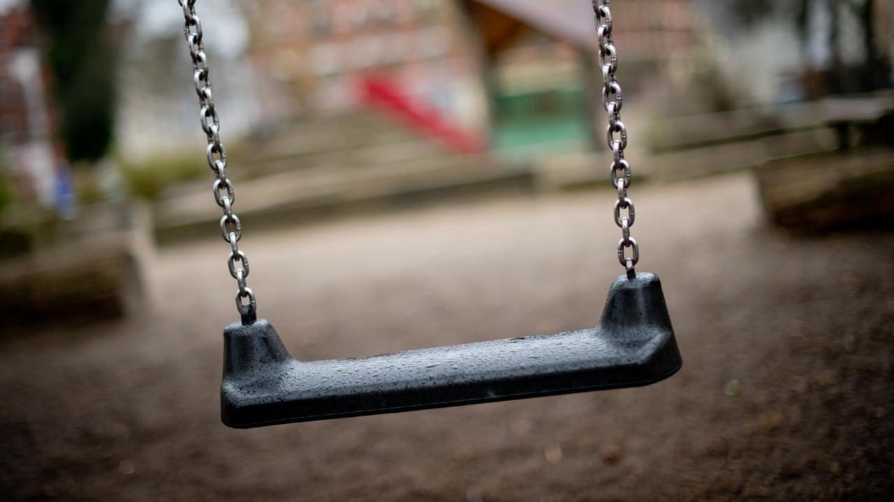 Leere Schaukel auf einem Spielplatz Leere Schaukel auf einem Spielplatz
