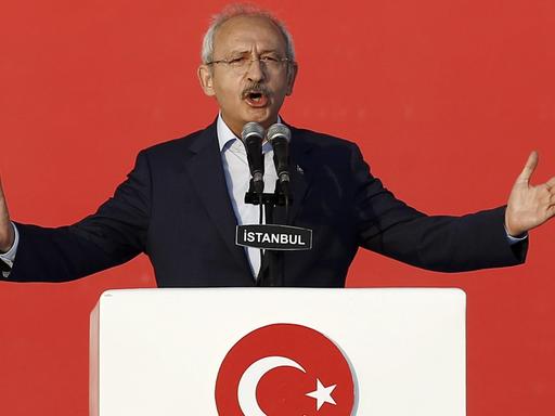Das Bild zeigt den türkischen Oppositionsführer Kemal Kilicdaroglu, Chef der sozialdemokratischen Partei CHP. Er steht an einem Rednerpult vor rotem Hintergrund.