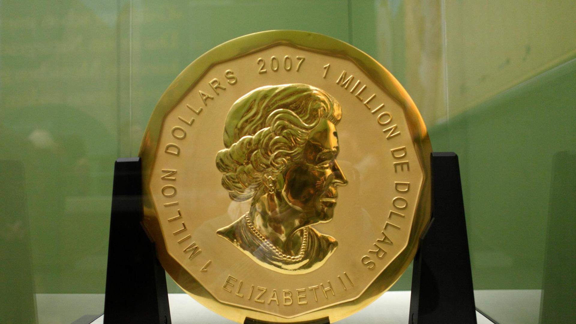 Die große goldene Münze mit dem Bild von Königin Elizabeth II. in einer Vitrine im Museum. Die große goldene Münze mit dem Bild von Königin Elizabeth II. in einer Vitrine im Museum.