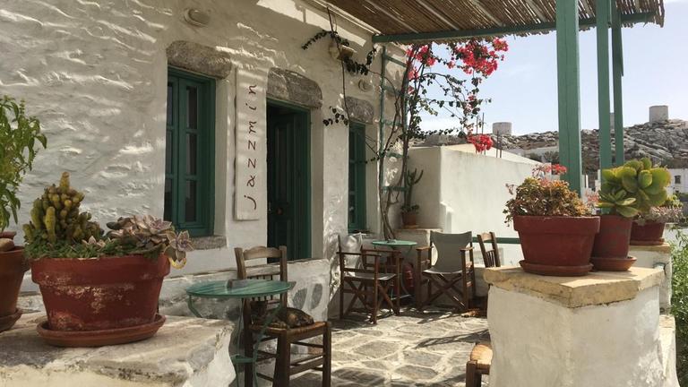 Die überdachte Terrasse eines Steinhäuschens mit Stühlen und Tischen und Pflanzen. Die überdachte Terrasse eines Steinhäuschens mit Stühlen und Tischen und Pflanzen.
